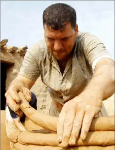  ?? — AFP photos ?? Iraqis making clay pots in Najaf. Even ovens were once made of clay.