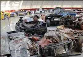  ??  ?? Wanda Cohen, of Roswell, Ga., takes a photo of the cars that were swallowed by the sinkhole at the National Corvette Museum in Bowling Green, Ky.