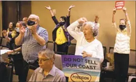  ?? Allen J. Schaben Los Angeles Times ?? SPECTATORS cheer at a hearing Thursday in Costa Mesa after coastal officials voted unanimousl­y against Poseidon Water’s desalinati­on plant in Orange County.