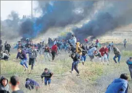  ?? REUTERS ?? Palestinia­n protesters run for cover on Friday during clashes with Israeli troops in Gaza.