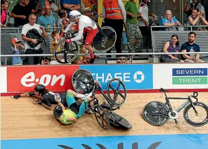  ?? AP ?? and were in a silver medal group at
New Zealand rider George Jackson escaped this crash on the velodrome in qualifying to help teammate Corbin Strong claim gold in the 15km scratch race final yesterday. England’s Matt Walls is airborne.