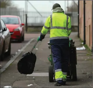  ??  ?? A refuse worker clears up rubbish in the city, but many staff now face an uncertain future Picture: Colin Mearns