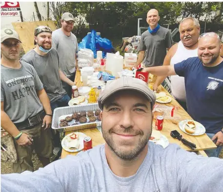  ?? PHOTOS: JOHN KINNEY ?? Electricia­n John Kinney, front, takes a lunch break with volunteers helping him repair the Massachuse­tts home of Gloria Scott.