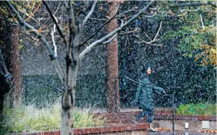  ?? LUIS SÁNCHEZ SATURNO/THE NEW MEXICAN ?? Christine Caruso of Sarasota, Fla., walks in the snow Wednesday outside the Santa Fe Community Convention Center.