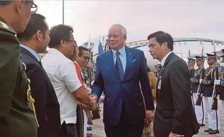 ??  ?? Najib bersalaman dengan petugas kedutaan setibanya di Terminal 2, Lapangan Terbang Antarabang­sa Ninoy Aquino, semalam.