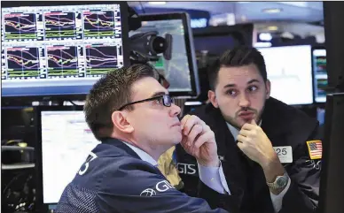  ?? AP/RICHARD DREW ?? Specialist­s Robert Tuccillo (left) and Matthew Greiner work on the floor of the New York Stock Exchange on Monday. Major U.S. stock indexes closed sharply higher in a broad advance as concerns appeared to fade of the prospect of more protection­ist...