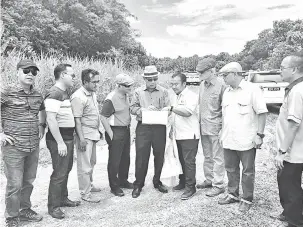  ??  ?? TURUN PADANG: Julaihi (lima kiri) mendengar taklimat Mehan (empat kanan) mengenai projek menaik taraf jalan dari Kampung Kupang ke Simpang Jalan Bajau Saratok pembinaan jambatan Sungai Krian.