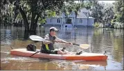  ?? JOE RAEDLE / GETTY IMAGES ?? Steve Jolly uses a kayak to maneuver around his flooded neighborho­od in Summervill­e, S.C., on Wednesday. Officials expect the damage from the flooding waters to be in the hundreds of millions of dollars.