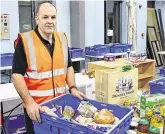  ??  ?? Helping hand: Colm Kelly sorts through donations in the warehouse