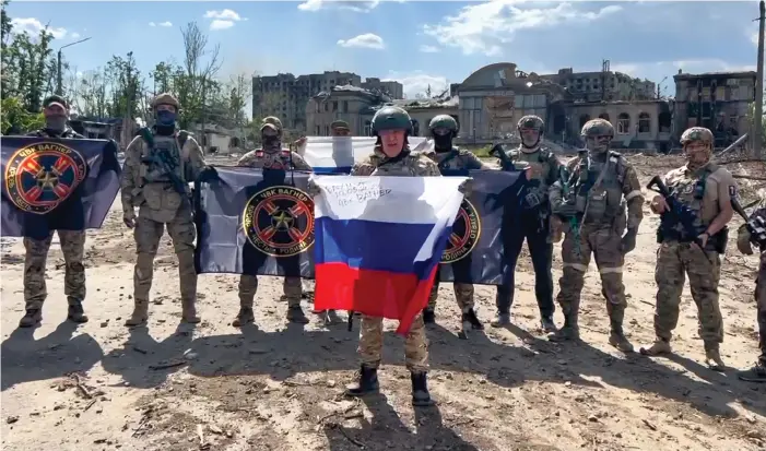  ?? BILD: PRIGOZJINS EGEN PRESSTJÄNS­T VIA AP ?? Jevgenij Prigozjin, som håller den ryska flaggan, poserar med soldater i Bachmut. Bilden distribuer­ades den 20 maj.