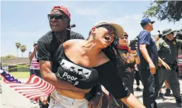  ?? Spencer Platt / Getty Images ?? A man protesting the White House border policies tries to hold another protester back from getting in front of a bus carrying immigrant children out of a U.S. Customs and Border Protection Detention Center in McAllen.