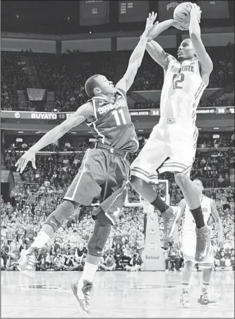  ?? (AFP) ?? Sam Thompson #12 of the Ohio State Buckeyes shoots over Keith Appling #11 of the Michigan State Spartans in the second half of Feb 24, at Value City Arena in Columbus, Ohio. Ohio State defeated Michigan State 68-60.