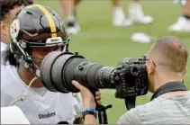  ?? Matt Freed/Post-Gazette ?? A BIG SMILE
Zach Banner has some fun with Steelers team photograph­er Karl Roser Thursday during practice at Heinz Field.