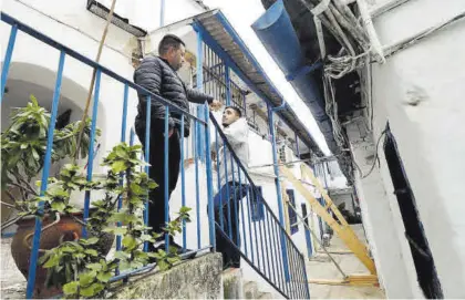  ?? MANUEL MURILLO ?? Afectados por el desalojo de la Casa de Paso, con los puntales instalados por los bomberos.