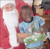  ??  ?? Santa brings a smile to yet another young face at the Mercury Hibberdene Children’s Holiday Home.