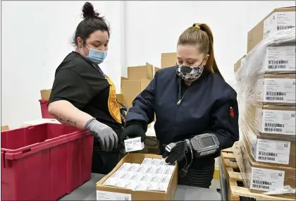  ?? TIMOTHY D. EASLEY — THE ASSOCIATED PRESS ?? Employees with the McKesson Corp. scan a box of the Johnson & Johnson COVID-19vaccine while filling an order at its shipping facility in Shepherdsv­ille, Ky., on Monday. The pandemic has killed more than 500,000America­ns.