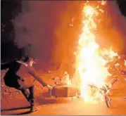  ?? AFP ?? A policeman attempts to remove a burning motorbike from a street in Karachi early on Saturday after it was set alight by protestors anticipati­ng the arrest of Khadim Hussain Rizvi.