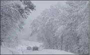  ?? (AP) ?? Cars make their way on a snow covered road Monday in Kocevje, near Ljubljana, Slovenia.