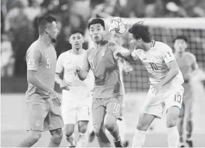  ?? (AP) ?? Phil Younghusba­nd (right) fights for the ball with Chinese Zheng Zhi during their AFC Asian Cup Group C match Friday at Mohammed Bin Zayed Stadium in Abu Dhabi. The Chinese won 3-0.