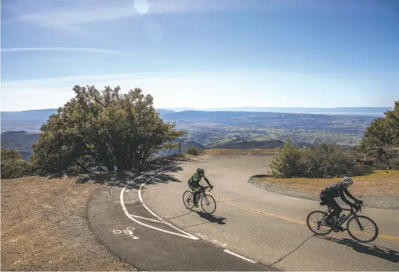  ?? Photos by Stephen Lam / The Chronicle ?? Bicyclists climbing Mount Diablo ride by a turnout on Summit Road. State Parks officials say bikecar crashes are at near zero since the turnouts were installed.