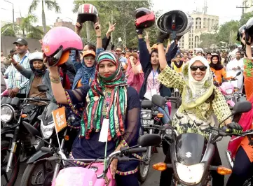  ??  ?? Pakistani women celebrate as they ride during the pink motorcycle­s rally in Lahore. — AFP photo