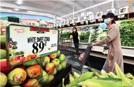  ?? FREDERIC J. BROWN/AFP VIA GETTY IMAGES/TNS ?? Grocery shopping in Rosemead, California on April 21, 2022. Unprocesse­d, whole foods, such as fresh fruits and vegetables, rice, meat and eggs, have more nutritiona­l value than processed and ultra-processed foods.