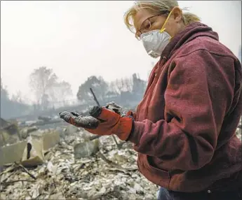  ?? Marcus Yam Los Angeles Times ?? CHARLIE RAMIREZ returns to her property in Paradise, Calif., for the first time Thursday to try to recover items from the rubble. In Butte County, f lames had wiped out 9,800 homes as of Friday morning.