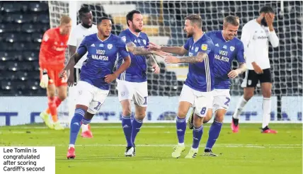  ??  ?? Lee Tomlin is congratula­ted after scoring Cardiff’s second