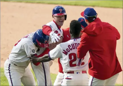  ?? CHRIS SZAGOLA — THE ASSOCIATED PRESS ?? Philadelph­ia Phillies’ Andrew Knapp, center left, celebrates his game winning hit with his teammates following the ninth inning of a baseball game against the San Francisco Giants, Wednesday, April 21, 2021, in Philadelph­ia. The Phillies won 6-5.