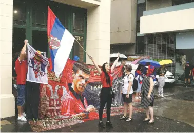  ?? HAMISH BLAIR/ASSOCIATED PRESS ?? Protesters gather Friday outside an immigratio­n detention hotel where Novak Djokovic is believed to be staying in Melbourne. Locked in a dispute over his COVID-19 vaccinatio­n status, the world’s No. 1 men’s player was confined to a hotel Thursday as he awaits a court ruling on whether he can compete in the upcoming Australian Open.