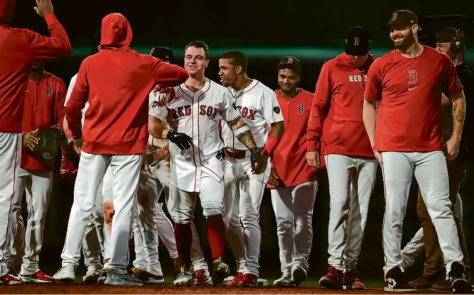  ?? JAIDEN TRIPI/GETTY IMAGES ?? Tyler O’Neill (center) walked off the field at Fenway Park as the hero following his bloop single to left field that produced a Red Sox win over the Cubs.