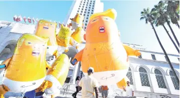  ??  ?? Anti-Trump protesters float ‘Baby Trump’ balloons in front of City Hall as they demonstrat­e before the 2018 mid-term elections, in Los Angeles, California. — AFP photo