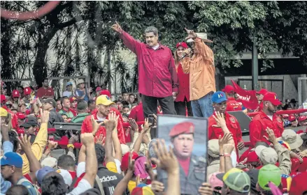  ??  ?? SIGNALLING SUPPORT: President Nicolas Maduro of Venezuela, left, waves to cheering government workers at a rally in Caracas.