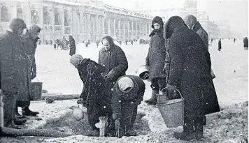  ??  ?? DARK DAYS: Residents of besieged Leningrad fill their buckets with water from a pump on Nevsky Avenue, 1942