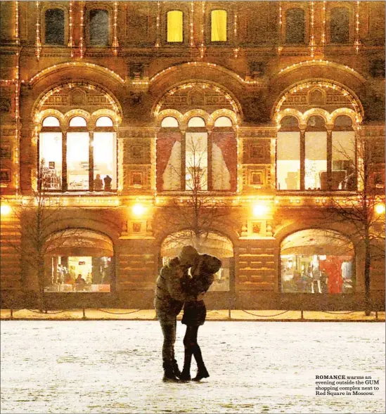  ?? Christophe­r Reynolds Los Angeles Times ?? ROMANCE warms an evening outside the GUM shopping complex next to Red Square in Moscow.