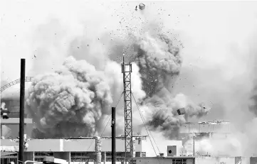  ??  ?? Debris fly as smoke rises after an artillery attack on the Islamic State militants’ positions by the Iraqi Army in the Shifa neighbourh­ood during clashes in western Mosul, Iraq. — Reuters photo