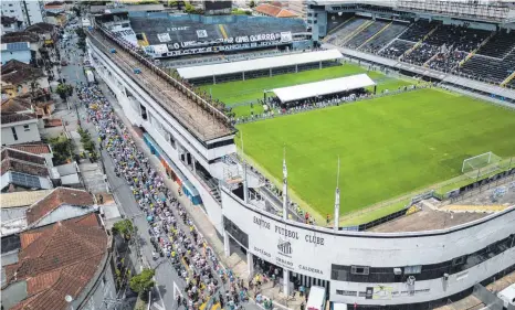  ?? FOTO: MATIAS DELACROIX/DPA ?? Brasiliani­sche Fans stehen Schlange, um der verstorben­en brasiliani­schen Fußballleg­ende Pelé in Santos die letzte Ehre zu erweisen.