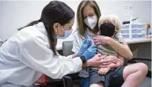  ?? SEAN RAYFORD / AP ?? Kaitlin Harring administer­s a Moderna COVID-19 vaccinatio­n to Fletcher Pack, 3, while he sits on his mother’s lap, at a Walgreens on Monday in Lexington, S.C.