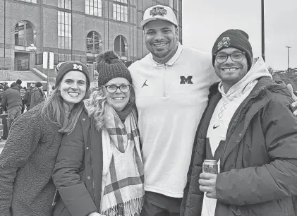  ?? COURTESY OF THE NEWSOME FAMILY ?? Kim Newsome (second from left) visits a Michigan football game last season to see her son Grant (second from right), who is an assistant coach for the team. Grant’s wife, Caroline, is on her left and brother Garrett is on the far right.