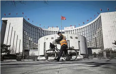  ??  ?? Financial regulator: A man pushes a bicycle past the PBoC’s headquarte­rs in Beijing. China sent a signal it plans to press ahead with opening up the US$40 trillion financial sector. — Bloomberg