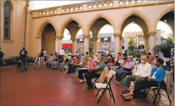  ?? NELVIN C. CEPEDA U-T PHOTOS ?? Parishione­rs sit outside in the courtyard for a Holy Week service at St. Paul’s Episcopal Cathedral on Thursday. St. Paul’s plans to slowly reintroduc­e indoor services later this month, with limits and modificati­ons.