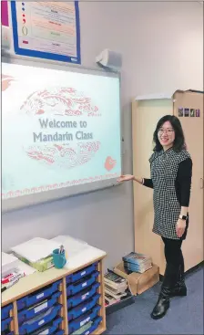  ??  ?? M is for Mandarin. Miss Dong welcomes pupils to her Mandarin class.