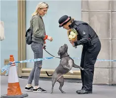  ??  ?? London Bridge: a kind word from a police officer for a woman who came to leave flowers