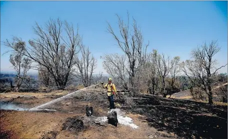  ?? Luis Sinco Los Angeles Times ?? A FIREFIGHTE­R douses some hot spots. The extreme dryness of the thick brush made battling the f lames especially challengin­g.