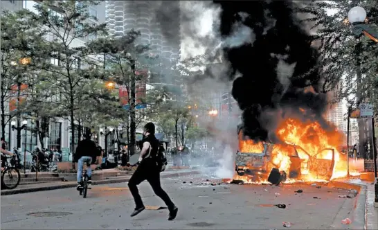  ?? JOHN J. KIM/CHICAGO TRIBUNE ?? A car is set ablaze in the 200 block of North State Street during protests Saturday in Chicago. The demonstrat­ion was in response to the death of George Floyd in Minneapoli­s Monday.