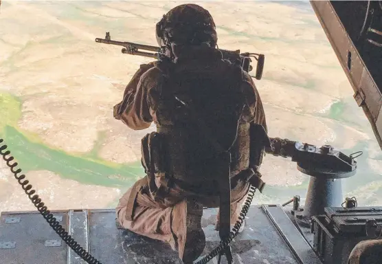  ?? Pictures: AFP ?? WATCHFUL: A gunner in a US Marine Corps V-22 Osprey near al-qaim, Iraq, and (below) US forces patrol in Al-darbasiyah in northeaste­rn Syria.