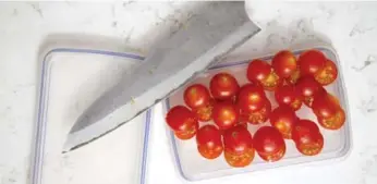  ??  ?? Cutting cherry tomatoes between two container lids will save a lot of time.