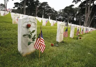  ??  ?? Six thousand roses and lilies are placed on tombstones at the Presidio cemetery for Memorial Day. Several hundred people gathered for the ceremony honoring the dead.