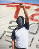  ?? Felix Marquez / Associated Press ?? A masked student holds a banner as hundreds of students block a highway in Chilpancin­go, Mexico. Missing students’ relatives are demanding answers a day after security forces found a mass grave.