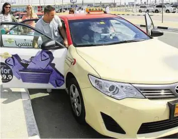  ??  ?? Easy access A passenger takes an RTA taxi at Al Maktoum Internatio­nal Airport. The RTA had offered 300 taxi number plates to all taxi franchises through an auction.
Zarina Fernandes/ Gulf News